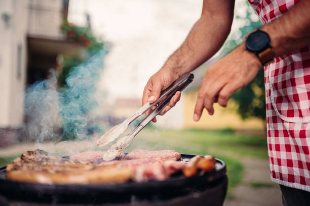 istock Men wearing apron barbecuing chicken meat 1193969995