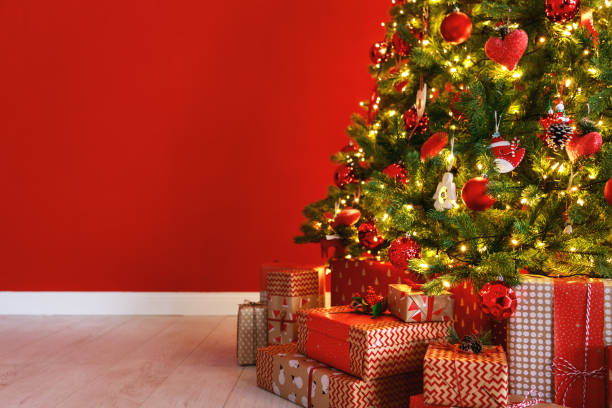 istock Christmas tree on the background of   red empty wall 1193971152