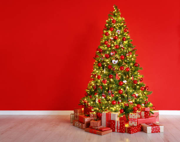 istock Christmas tree on the background of   red empty wall 1193971168