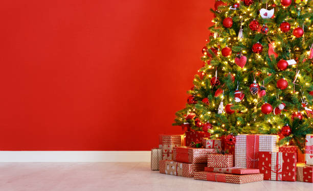 istock Christmas tree on the background of   red empty wall 1193971195