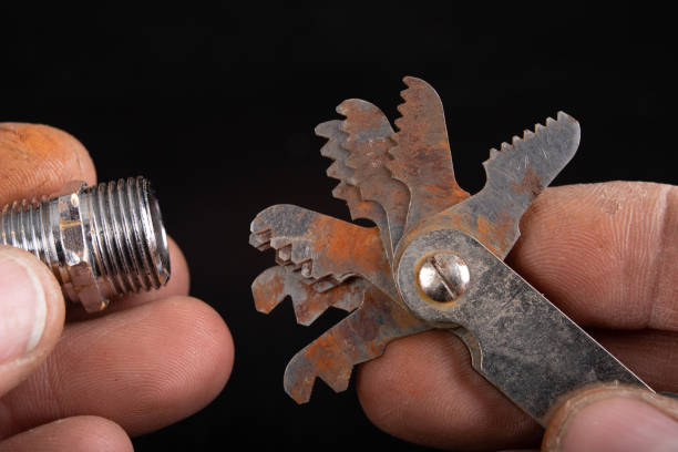 istock Checking the screw thread with an analog meter. Correctness of the threaded connection. Dark background. 1193972803