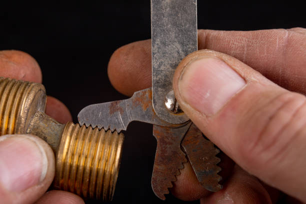 Checking the screw thread with an analog meter. Correctness of the threaded connection. Dark background.