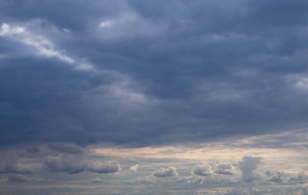 istock Dark stormy blue sky above with small white light clouds below. Natural cloudscape background. 1193972894