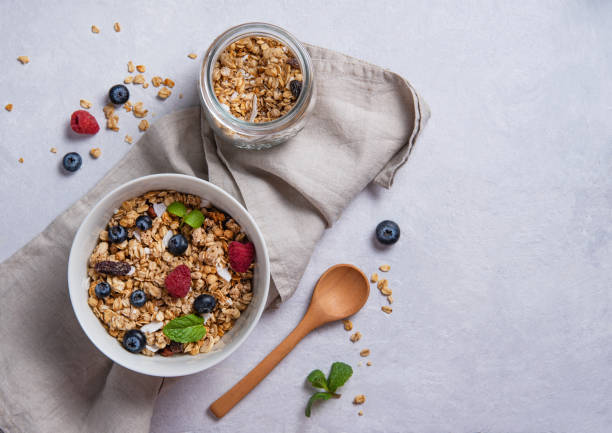 słodkie musli z jagodami na talerzu z mlekiem kokosowym na szarym stole. - oatmeal raisin porridge nut zdjęcia i obrazy z banku zdjęć