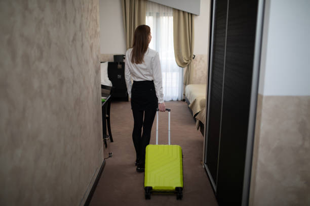 istock Businesswoman pulling a suitcase arriving in a hotel room 1193982640