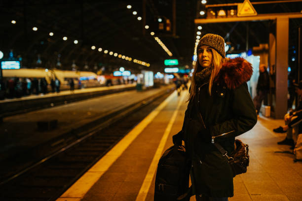 istock Young woman with a backpack waiting for a train 1193982697