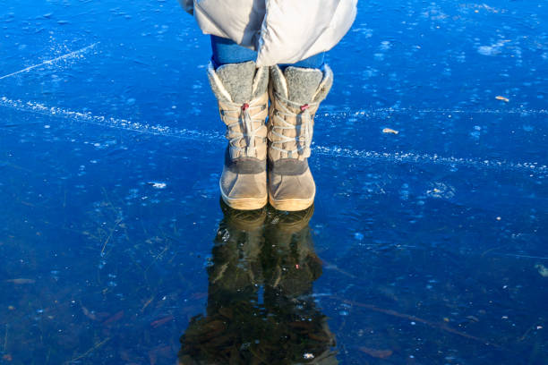 feet on frozen ice, frozen river, thick ice, woman standing on ice