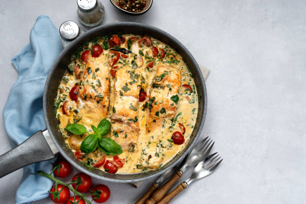 istock Delicious tuscan cream salmon with spinach in a black pan 1193988493