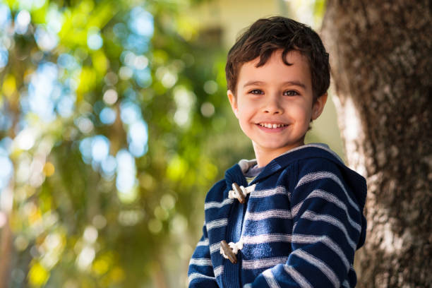 Cute boy outdoors Cute boy enjoying the outdoors sitting in a tree. one boy only photos stock pictures, royalty-free photos & images