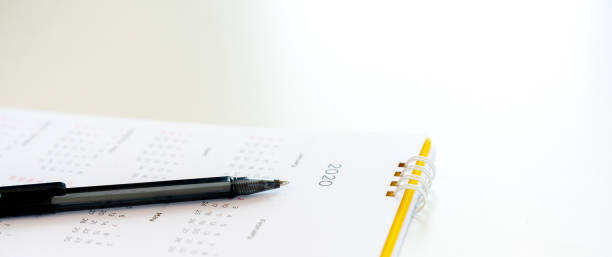 istock close up side view on  white calendar schedule background with pen to make appointment meeting or manage timetable each day for planning work in new year 2020 resolution concept 1193998155