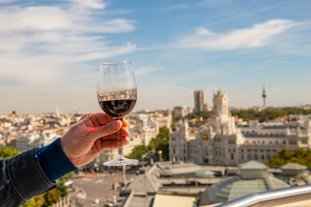 A glass of red wine held up for a toast in Madrid, Spain. stock photo