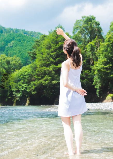 istock woman standing beside the river 1194002291