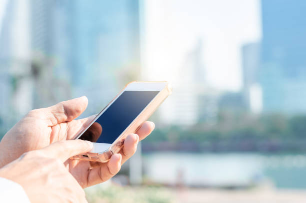 istock 5G technology world wide web connecting. close up business man using hand typing smartphones and touch screen working search with app devices outdoor in city with sunrise and building background. 1194003223