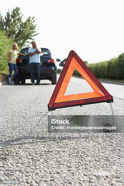 Photo libre de droit de Couple Abattu Sur Route De Campagne Avec Panneau Davertissement De Danger banque d'images et plus d'images libres de droit de Accident bénin