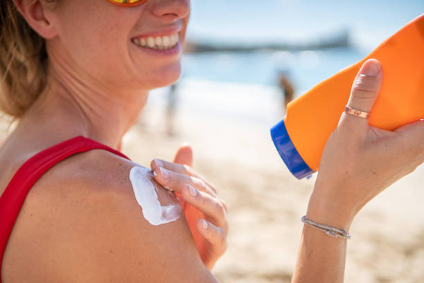 istock Woman on beach applying sunscreen 1194008225