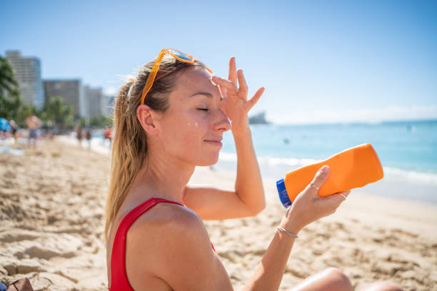 istock Woman on beach applying sunscreen 1194009022