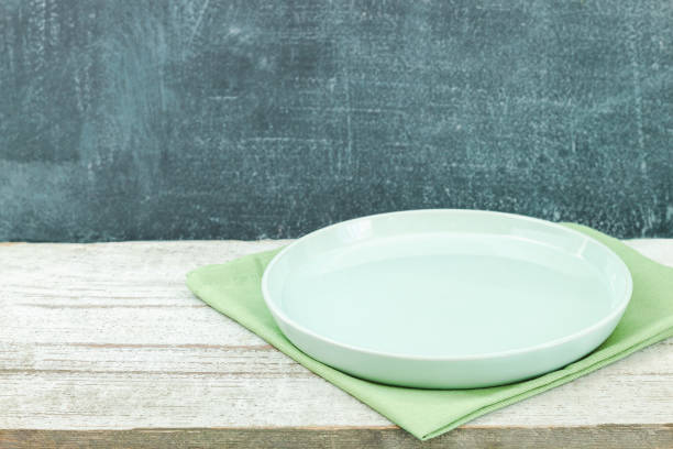Empty plate on tablecloth on wooden table over grunge blue background