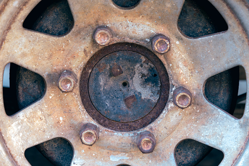 Close up of rusty hubcap of abandoned car.