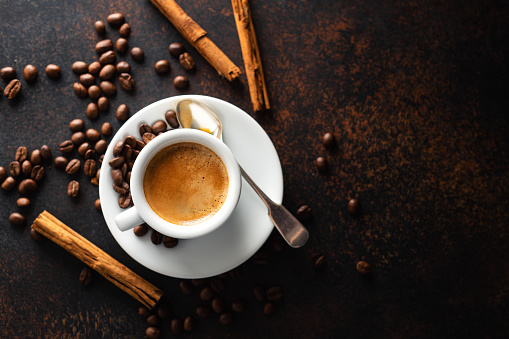 Cup of fresh made coffee served in cup on dark background. Coffee background.  Horizontal.