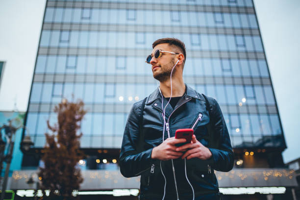 istock Young Man Listening To Music While Walking 1194019764