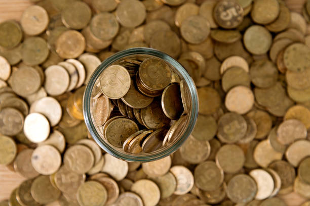 istock Coins in glass jar on wooden table 1194023575