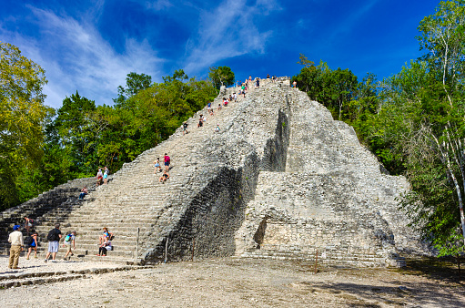Coba, Mexico - January 18, 2019:  Tourists climbing the Nohoch Mul Pyramid in Coba, Mexico.