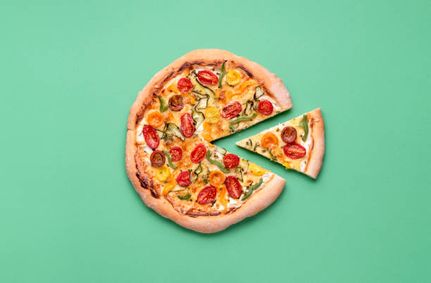 Pizza primavera and one slice. Single piece of vegetarian pizza stock photo