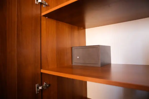 Metal safe inside an empty wooden closet in a hotel room