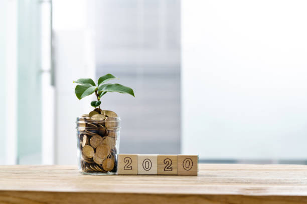 istock Coin jar and number 2020 on the table 1194032186