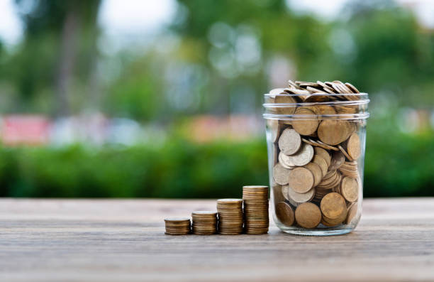 istock Coin stairs and jar on wooden table 1194032415