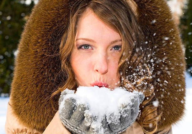 istock pretty girl blowing snow 119403327