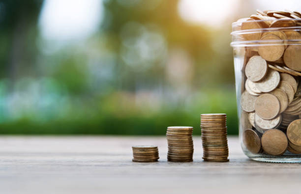 istock Coin stairs and jar on wooden table 1194043027