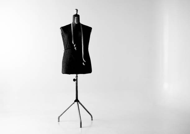Dress form backlit against a window with net curtains.