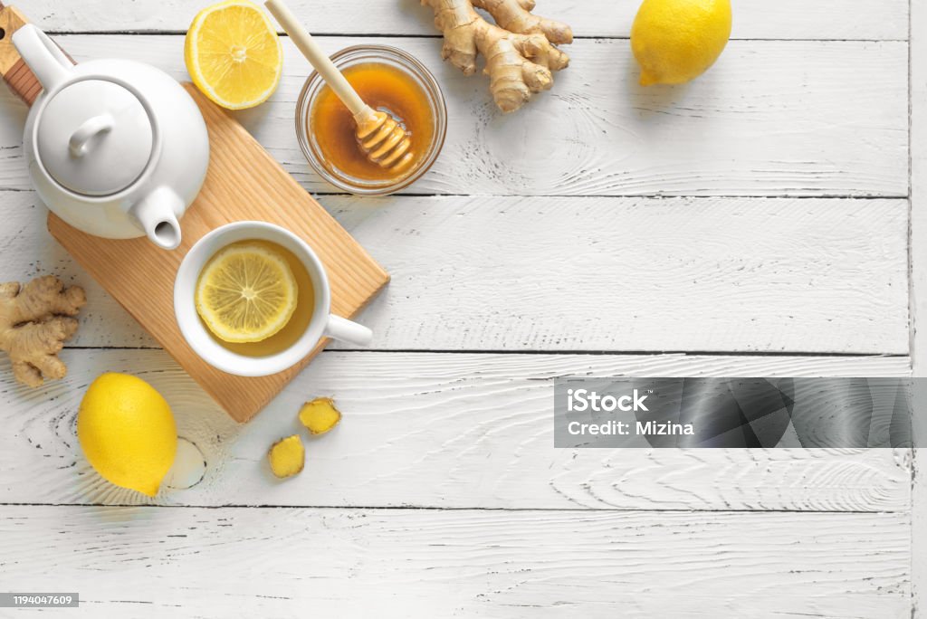 Ginger Lemon Tea Ginger Lemon Tea with Honey. Warming immune boosting tea with lemon and ginger. Cup, teapot, ginger root on white wooden background, top view, copy space. Tea - Hot Drink Stock Photo