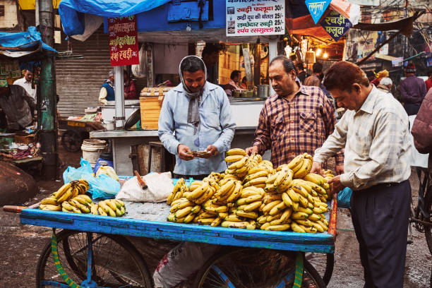banana vendors at their stall on the street in new delhi, india - consumerism indian ethnicity india delhi imagens e fotografias de stock