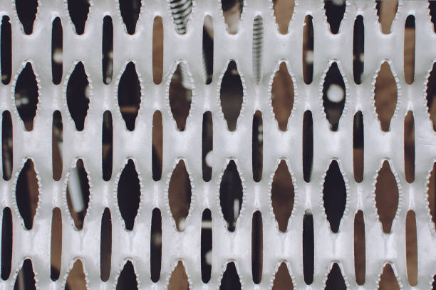 istock Grey perforated metal background. Metal stamped surface with perforation. 1194050308