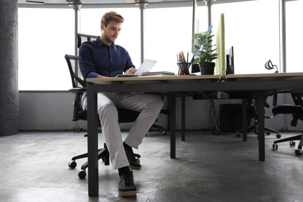 istock Young modern business man working using digital tablet while sitting in the office. 1194051618