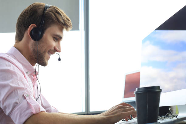 istock Smiling friendly handsome young male call centre operator. 1194053851