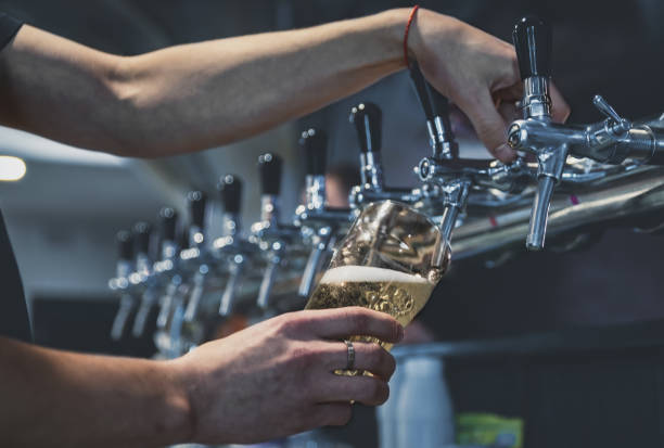 istock bartender hand at beer tap pouring a draught beer in glass serving in a restaurant or pub 1194055019
