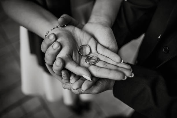istock Lovely couple holding wedding rings 1194057494