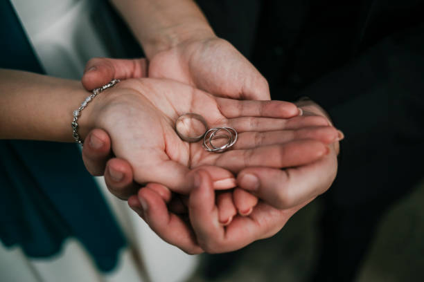 istock Lovely couple holding wedding rings 1194057499