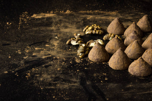 Chocolate truffles on a dark background with nuts. Selective focus