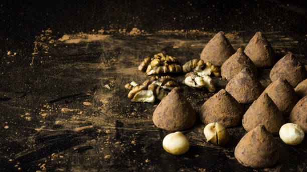 Chocolate truffles on a dark background with nuts. Selective focus