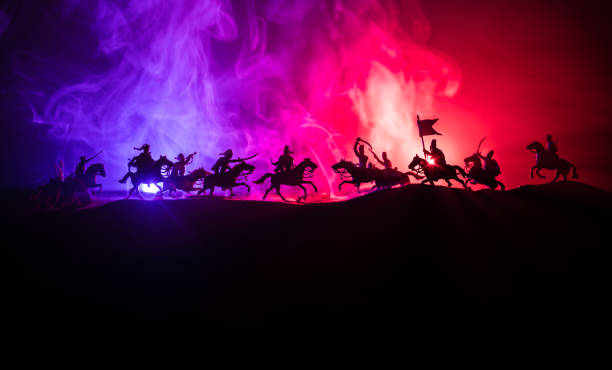 istock Medieval battle scene with cavalry and infantry. Silhouettes of figures as separate objects, fight between warriors on dark toned foggy background. Night scene. 1194062479