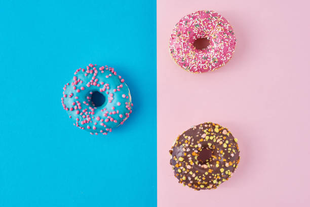 istock Donuts on a pastel pink and blue background. Minimalism creative food composition. Flat lay style 1194070551