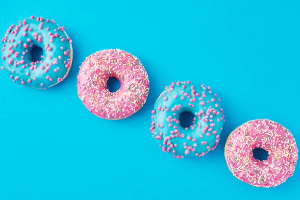 istock Different types of a colorful donats decorated sprinkles and icing on blue background 1194070558