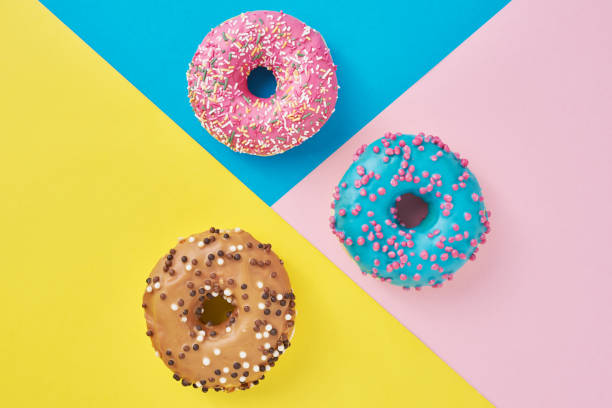 istock Donuts on a pastel pink, yellow and blue background. Minimalism creative food composition. Flat lay style 1194070572