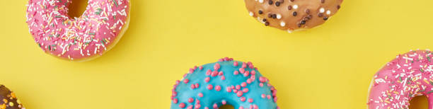 istock Color donut pattern on a yellow background, long banner 1194071077