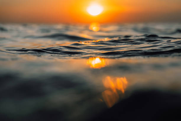 istock Sunset and waves in ocean. Warm water texture with bokeh 1194071311