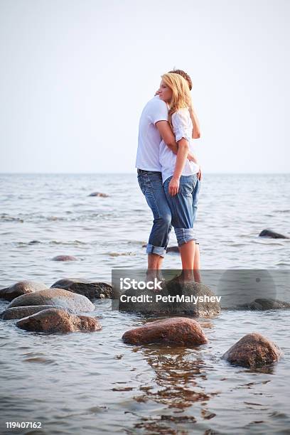 Couple Embrace On A Stone In Sea Stock Photo - Download Image Now - Blond Hair, Embracing, Men